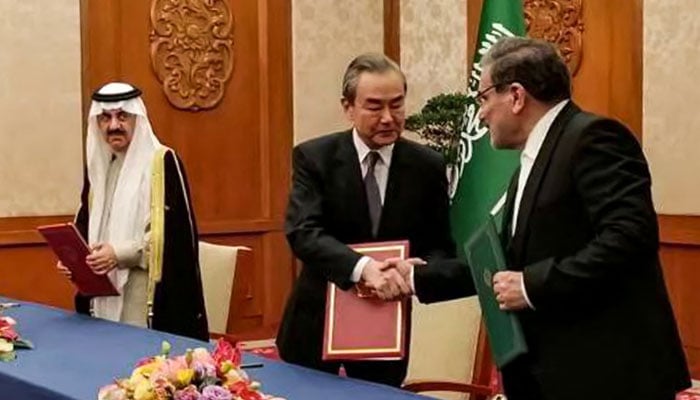 This handout image provided by Nournews agency shows the Secretary of the Supreme National Security Council of Iran Ali Shamkhani (R) shaking hands with the Director of the Office of the Central Foreign Affairs Commission of the Chinese Communist Party (CCP) Wang Yi (C) during a meeting with Saudi Arabia´s National Security adviser and Minister of State Musaad bin Mohammed al-Aiban (L) in Beijing on March 10, 2023. AFP