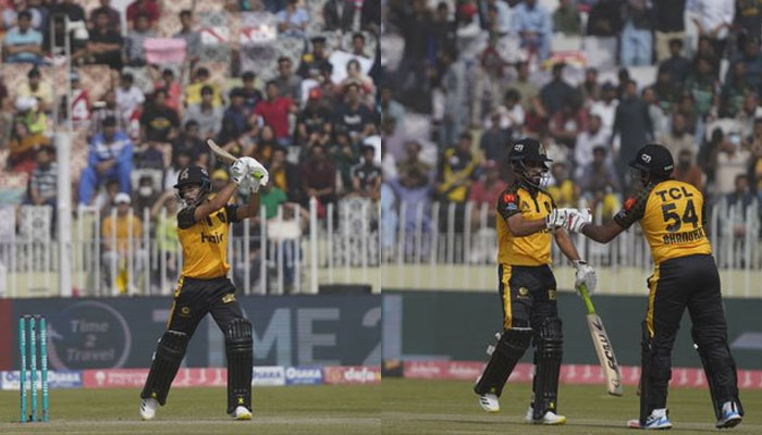 Peshawar Zalmi batter Muhammad Haris playing a stroke (L) and Zalmi players Muhammad Haris and Bhanuka Rajapaksha shaking fists. — Twitter@thePSLt20