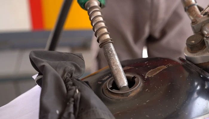 An employer of a petrol pump fills the fuel tank of a bike in Karachi, on March 17, 2023. — TheNews