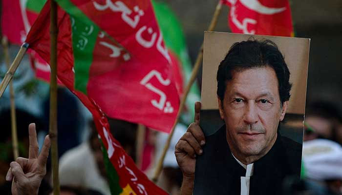 A PTI supporter holds an image of Pakistan Tehreek-e-Insaf Chairman Imran Khan during a rally. — AFP/File