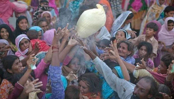 A representational image of people trying to get hold of a flour sack at a distribution point. — Twitter
