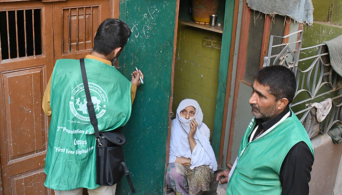An official from the Pakistan Bureau of Statistics uses a digital device to collect information from a resident during door-to-door the first-ever digital national census in Karachi on March 3, 2023. — Online