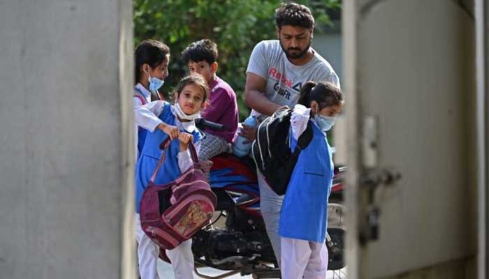 Children carry their bags to school. — AFP/File
