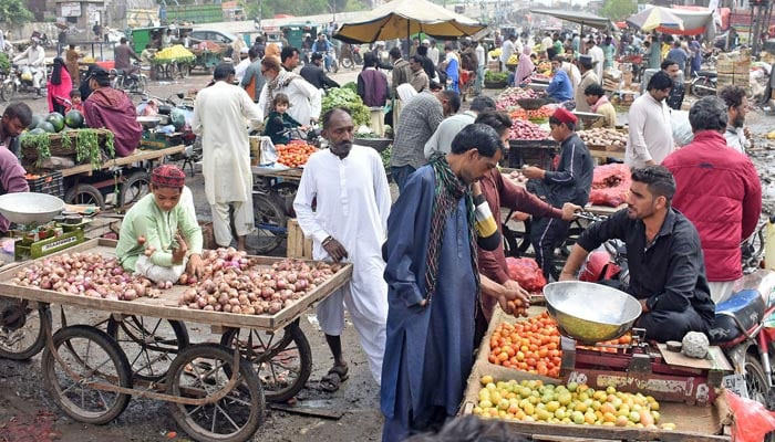 Vendors are selling vegetables at a market in Lahore on March 26, 2023. — Online