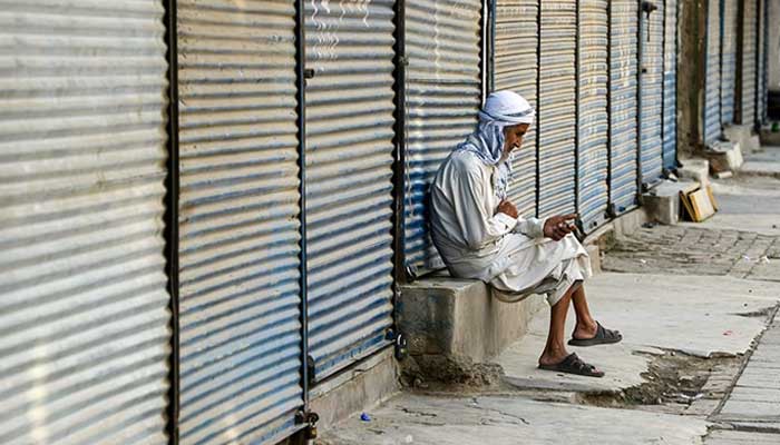 An elderly man sits at a shuttered market during a traders countrywide strike against the price hike, in Peshawar. — AFP/File