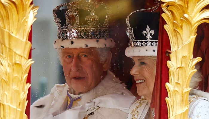 Britains King Charles III and Queen Camilla travel in the Gold State Coach, back to Buckingham Palace from Westminster Abbey in central London on May 6, 2023, after their coronations. — AFP