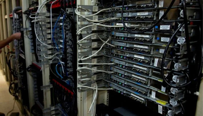 A computer engineer checks equipment at an internet service provider. —File
