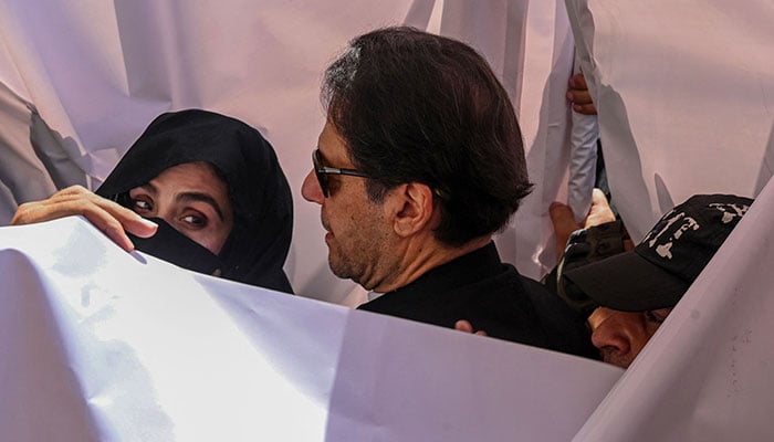 Former Pakistan prime minister Imran Khan (C) with his wife Bushra Bibi (L) arrive to appear at a high court in Lahore on May 15, 2023. Former Pakistan prime minister Imran Khan was due back in court on May 15 after his arrest and brief detention last week sparked days of deadly civil unrest. —AFP
