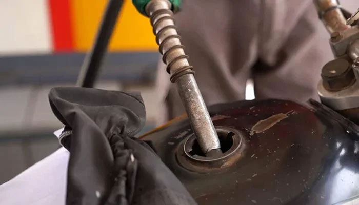 An employer of a petrol pump fills the fuel tank of a bike in Karachi, on March 17, 2023. — The News