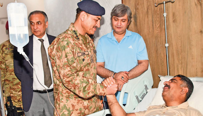 LAHORE: Chief of Army Staff General Asim Munir visiting the Services Hospital on Saturday to inquire after the health of a patient, who was injured during the May 9 violence.—The News