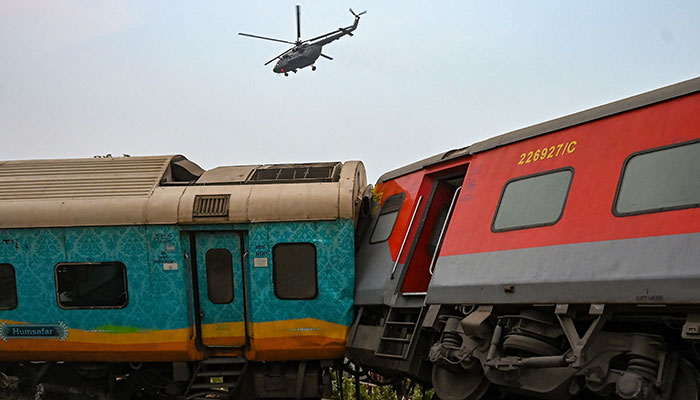 An army helicopter flies above the carriage wreckage of a three-train collision near Balasore, in India´s eastern state of Odisha, on June 3, 2023.—AFP