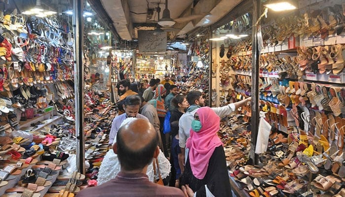 People shop at a market in Lahore, Pakistan on April 30, 2022. — AFP