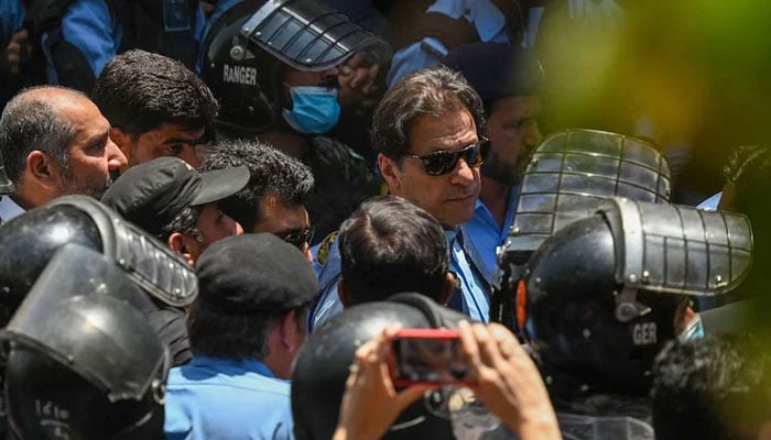 Amid heavy security, Imran Khan (centre) arrives for his court hearing in Islamabad on Friday. — AFP/File