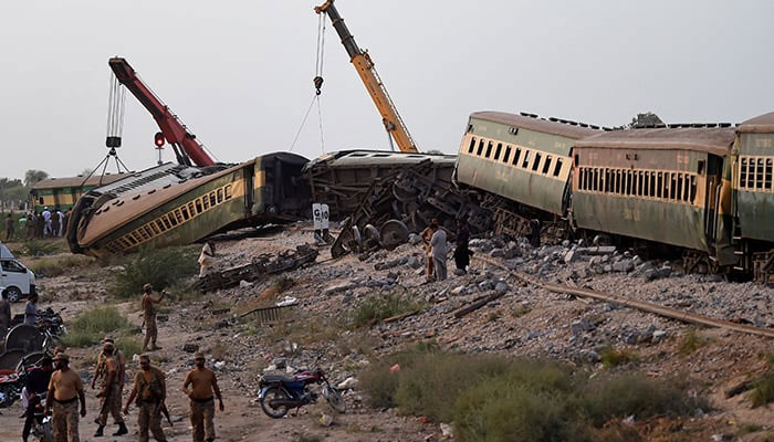Carriages are being lifted by cranes at the accident site following the derailment of a train in Nawabshah on August 6, 2023. — AFP