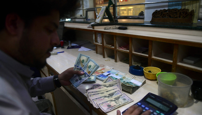 A dealer holds US dollars at a money exchange market in Karachi on January 26, 2023. — AFP