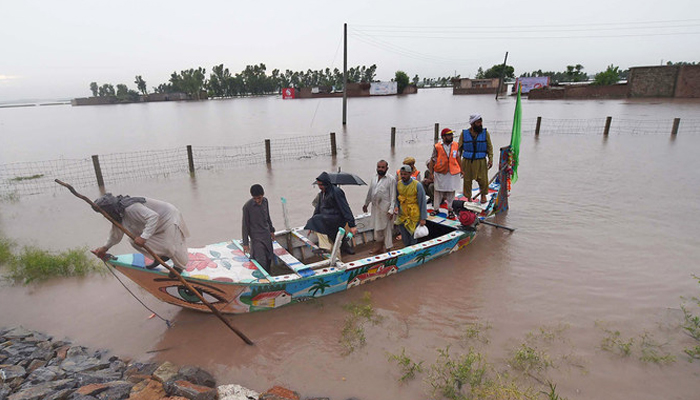 This photo shows volunteers rescuing flood-affected people with a boat in Pakistan. — AFP/File