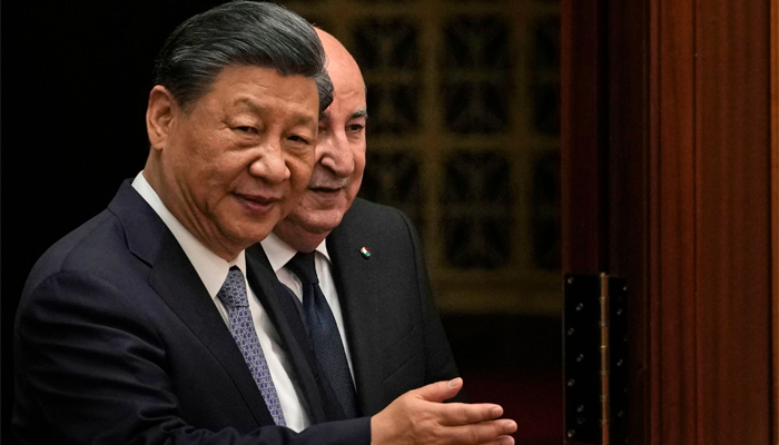 Chinas President Xi Jinping (L) shows the way to Algerias President Abdelmadjid Tebboune as they arrive to attend a signing ceremony at the Great Hall of the People in Beijing on July 18, 2023. — AFP
