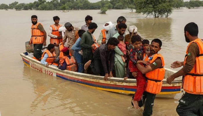 Rescue workers help to evacuate flood-affected people from their flood-hit homes following heavy monsoon rains in Rajanpur district of Punjab. — AFP/File
