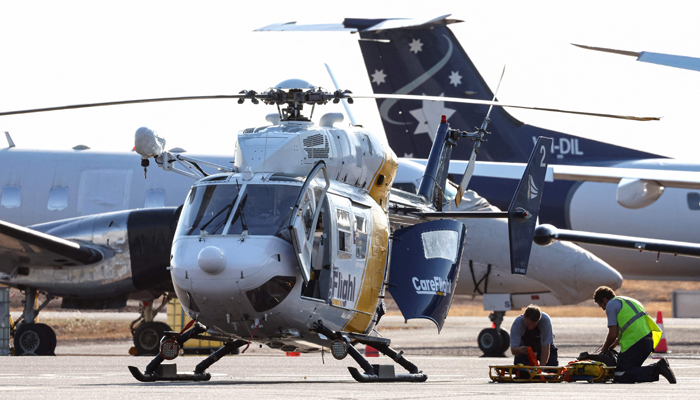 A Care Flight helicopter is seen on the tarmac of the Darwin International Airport in Darwin on August 27, 2023, as rescue work is in progress to transport injured in the US Osprey military aircraft crash at a remote island north of Australias mainland. — AFP