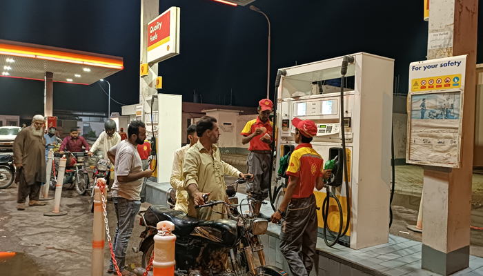 This image taken on July 22, 2023, shows people getting their motors bikes filled with petrol at a filling station on Hub River Road, Karachi. — Geo.tv