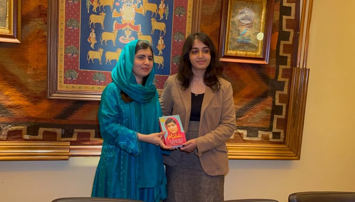 Nobel Peace Prize winner and education activist Malala Yousafzai (left) while presenting her book to  the remarkable fellow Pakistani Mahnoor Cheema who passed 34 GCSEs with A-stars, making a new UK and world record. — By the author