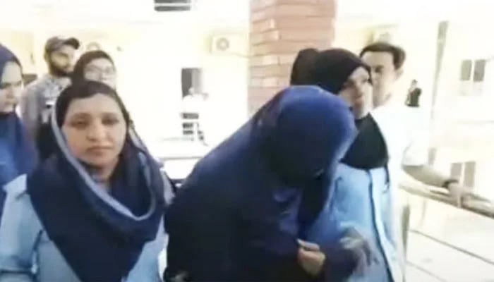 Prime suspect Somia Asim (centre) is being escorted by lady police officers at a court in Islamabad in this still taken from a video. — Geo News