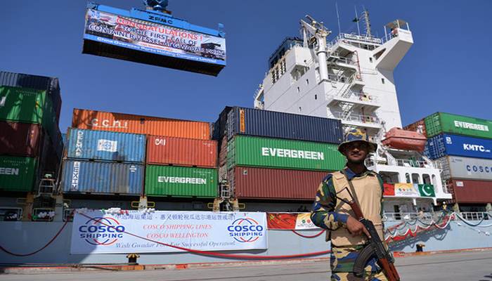 A Pakistani Naval personnel stands guard beside a ship carrying containers during the opening of a trade project. — AFP/File