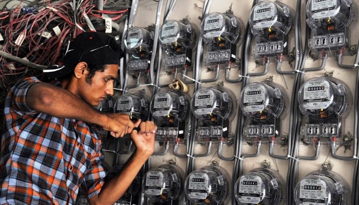 A power technician while fixing electric meters in Pakistan. — AFP/File