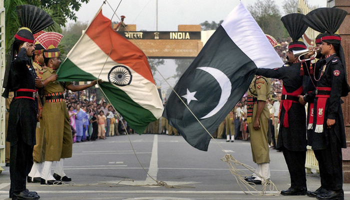 Pakistani (right) and Indian flags can be seen held by the border forces of each country. — AFP/File