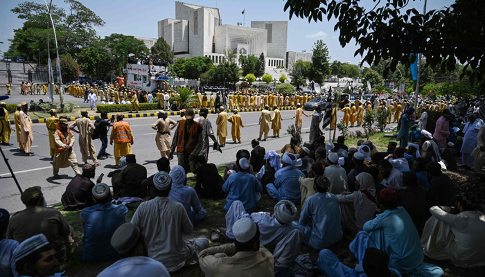 In this picture taken on May 15, 2023, supporters (foreground) of Pakistans ruling alliance gather outside the Supreme Court in Islamabad. — AFP