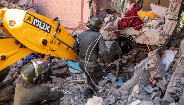 Rescuers use a small excavator to search for survivors under the rubble of a collapsed house in Moulay Brahim, Al Haouz province, on September 9, 2023, after an earthquake. — AFP