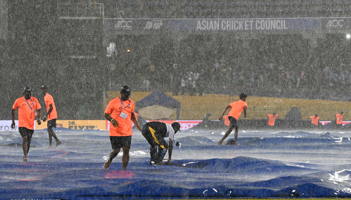 Ground staff cover the pitch as rain stops play during the Asia Cup 2023 Super Four ODI cricket match between India and Pakistan at the R. Premadasa Stadium in Colombo on September 10, 2023. — AFP