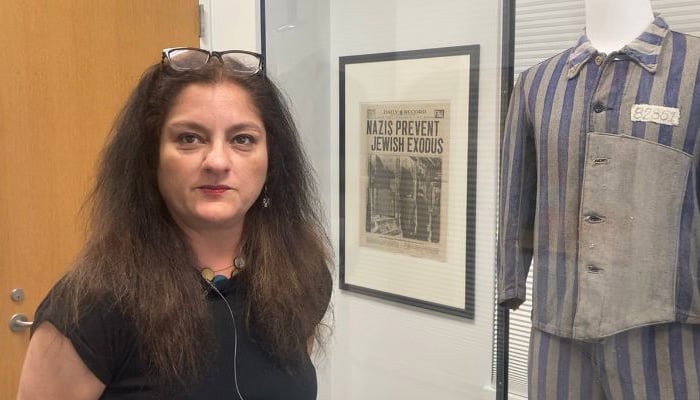 Pakistani-American professor Dr Mehnaz Afridi stands alongside the dress of a prisoner during World War II displayed in the museum at Manhattan College New York. — Photo by author