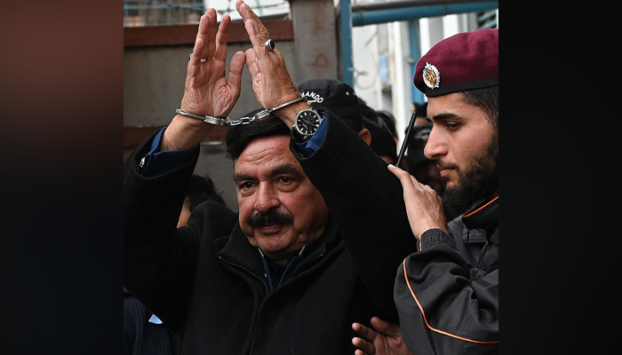 Police officials escort former interior minister Sheikh Rashid Ahmed (C) to present him before a court in Islamabad on February 2, 2023. — AFP