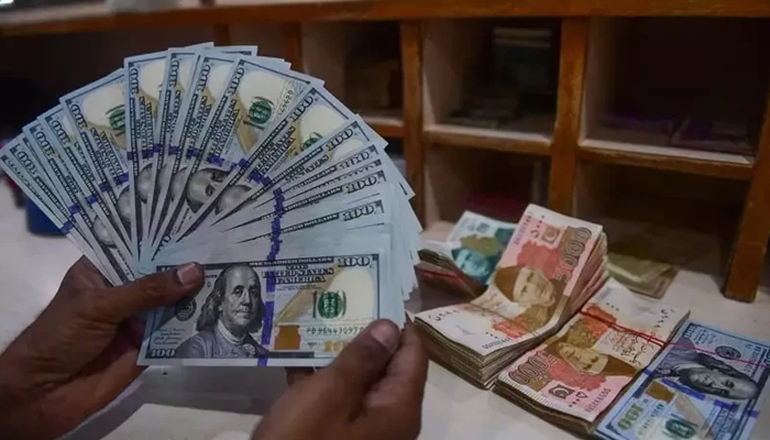 A foreign currency dealer counts US dollars at a shop in Karachi on May 19, 2022. AFP