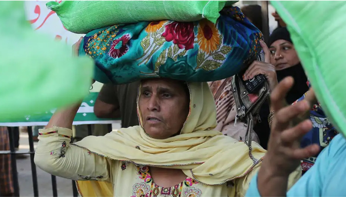 A woman while carrying her belongings in Karachi. — AFP/File