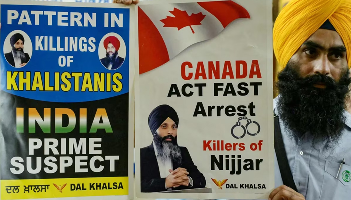 A member of a Sikh organisation holds a placard displaying Sikh separatist Hardeep Singh Nijjar in Amritsar on September 22, 2023. — AFP
