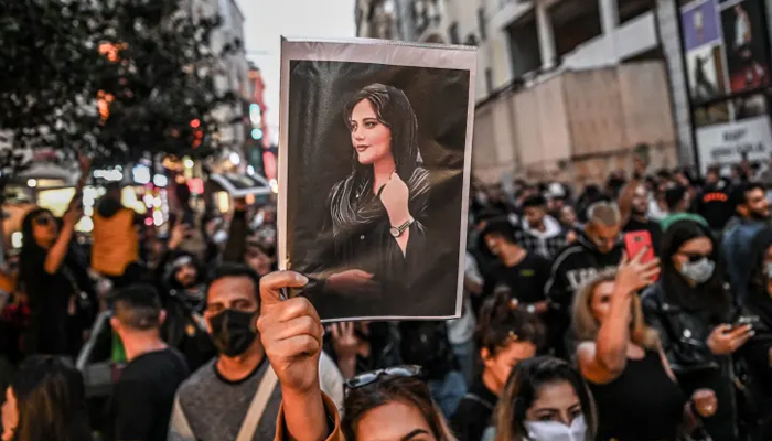 A protester holds a portrait of Mahsa Amini during a demonstration on Istiklal Avenue in Istanbul on September 20, 2022. — AFP