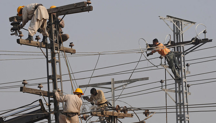 Technicians work on high-voltage power lines in Lahore. — AFP/File