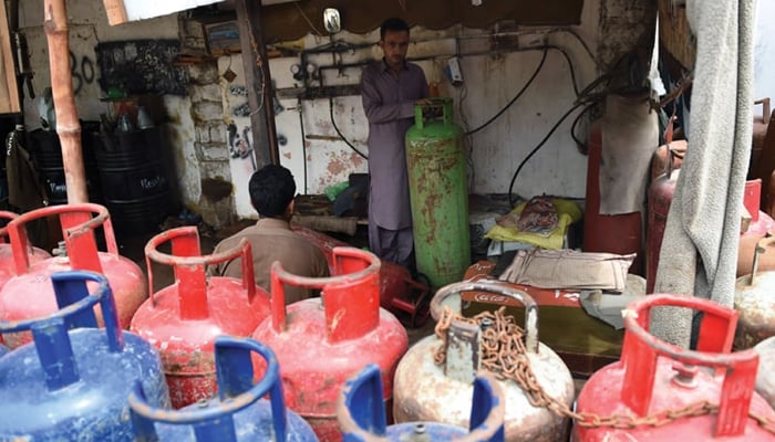 A person can be seen filling a Liquefied Petroleum Gas (LPG) cylinder. — AFP/File