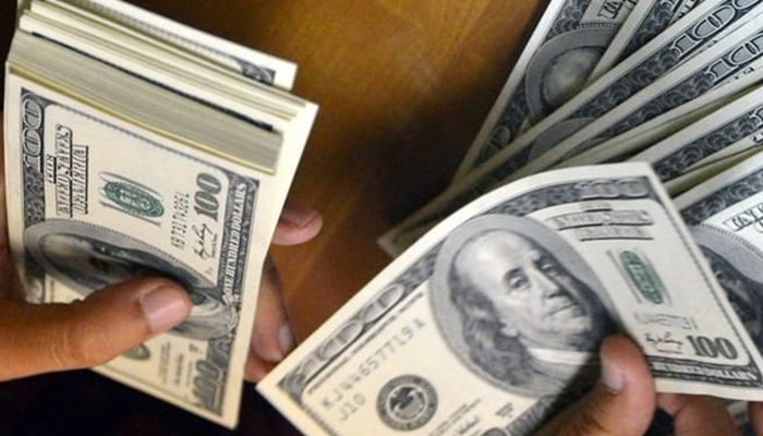 A person holds a stack of hundred dollar notes. — AFP/File