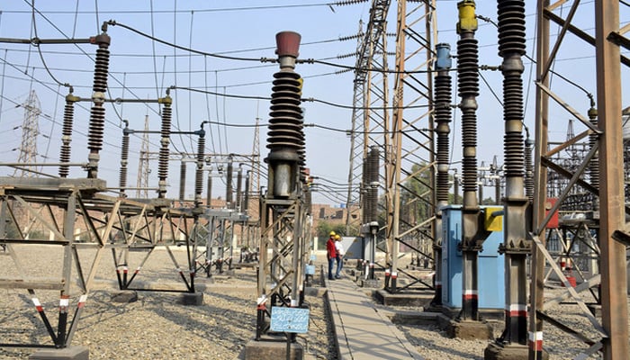 Pakistani technicians work at a power grid station in Faisalabad. — AFP/File
