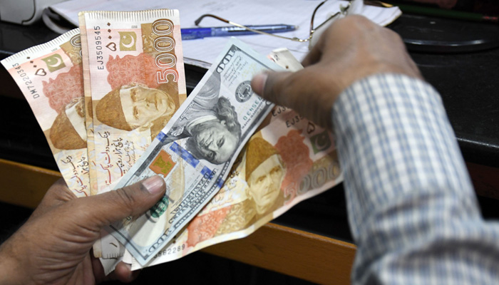 A foreign currency dealer counts US dollars at a shop in Karachi, Pakistan. — Online/File