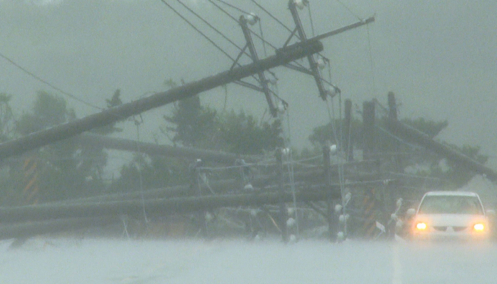 A car passes by power lines downed by the high winds from Typhoon Koinu in Taiwan´s southern Pingtung County on October 5, 2023. — AFP