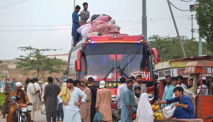Afghan refugees board a bus from Karachi, Pakistan, to Afghanistan on September 21, 2023. — AFP