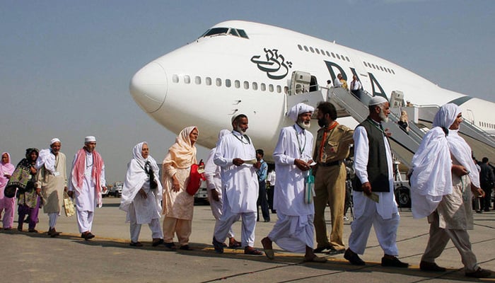 Pakistani pilgrims walk in line as they prepare to board a PIA special Hajj pilgrimage flight bound for Saudi Arabia. — AFP/File