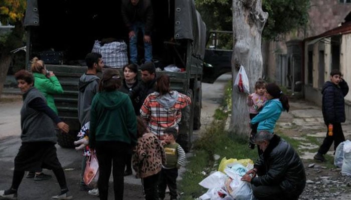 Refugees load a truck in Goris, Armenia, Sept. 26, 2023, before leaving to the capital Yerevan. A continuous stream of vehicles crept along the only road out of the Nagorno-Karabakh region toward Armenia, carrying tens of thousands of refugees. CBS