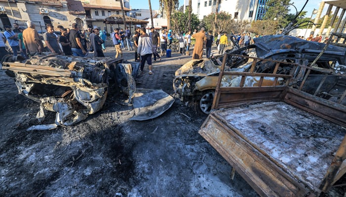 People search through debris outside the site of the Ahli Arab Hospital in central Gaza on October 18, 2023, in the aftermath of a blast there. — AFP