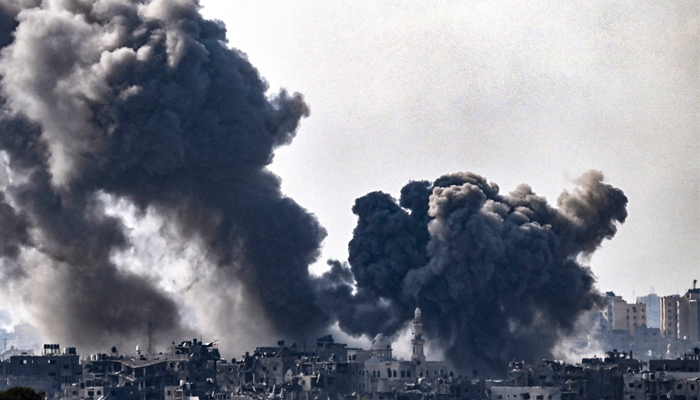 A picture taken from Sderot shows smoke plumes rising above buildings during an Israeli strike on the northern Gaza Strip on October 14, 2023. — AFP