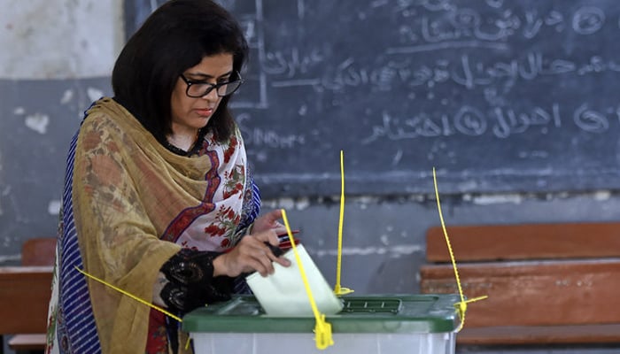 A female voter casts her ballot at a polling station during the by-election for national assembly seats, in Karachi, Pakistan, on October 16, 2022. — AFP